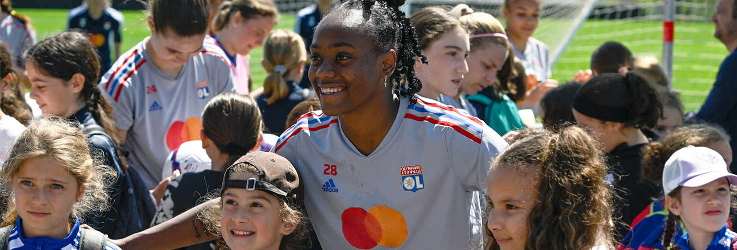 Photo d'une footballeuse de l'équipe féminine de l'OL avec de jeunes footballeuses